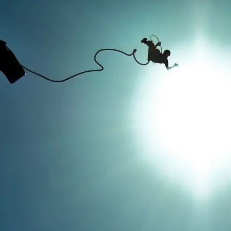 Bungee jumping with the shining sun above.